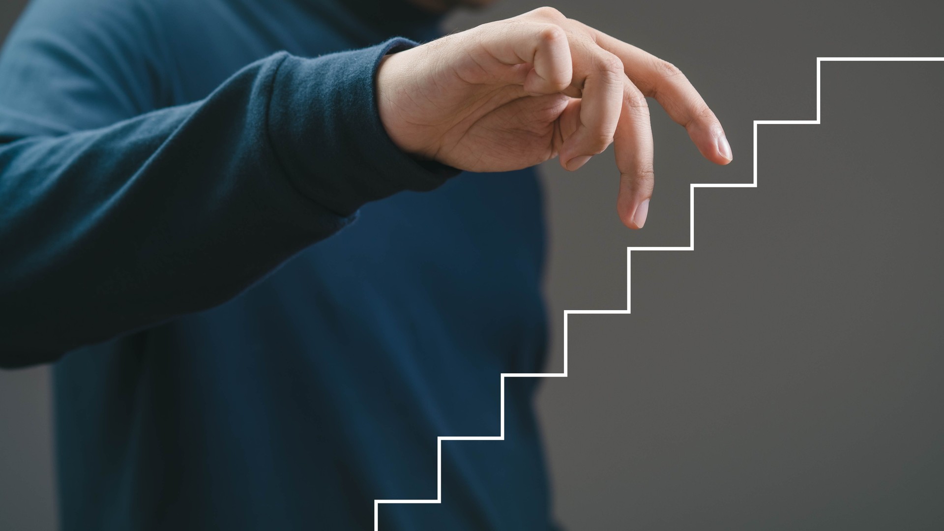A close-up of a hand reaching towards a creative graphic staircase, symbolizing progress and growth in a professional environment.